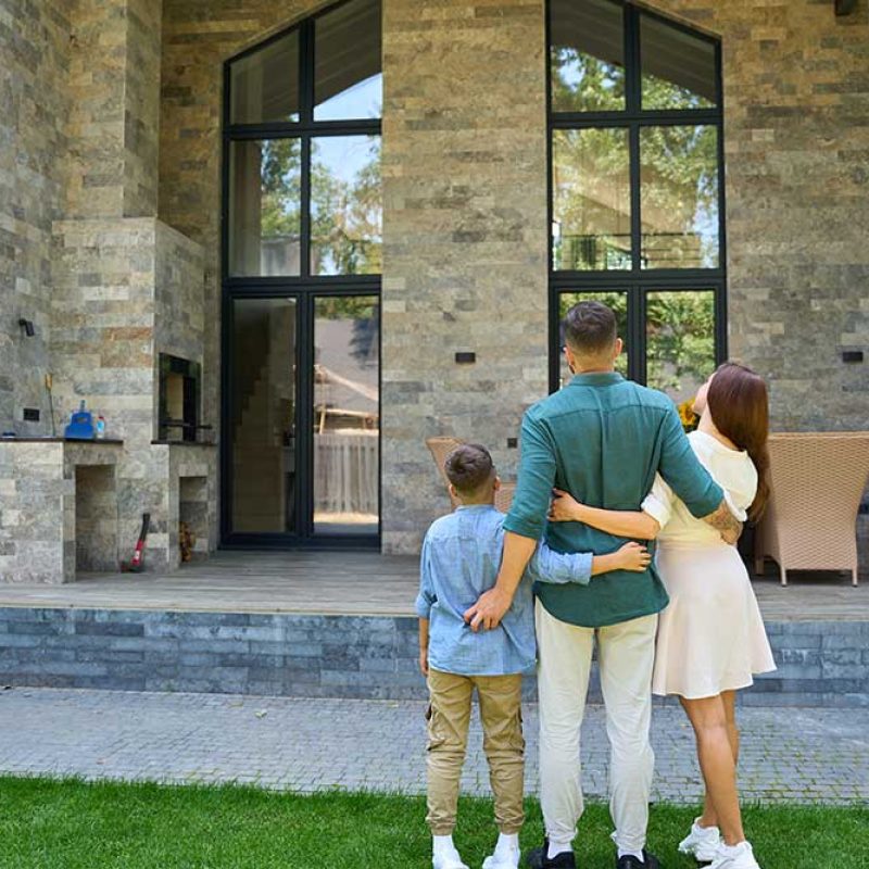 happy-family-stands-hugging-on-lawn-in-front-of-co-2026-01-08-06-53-29-utc